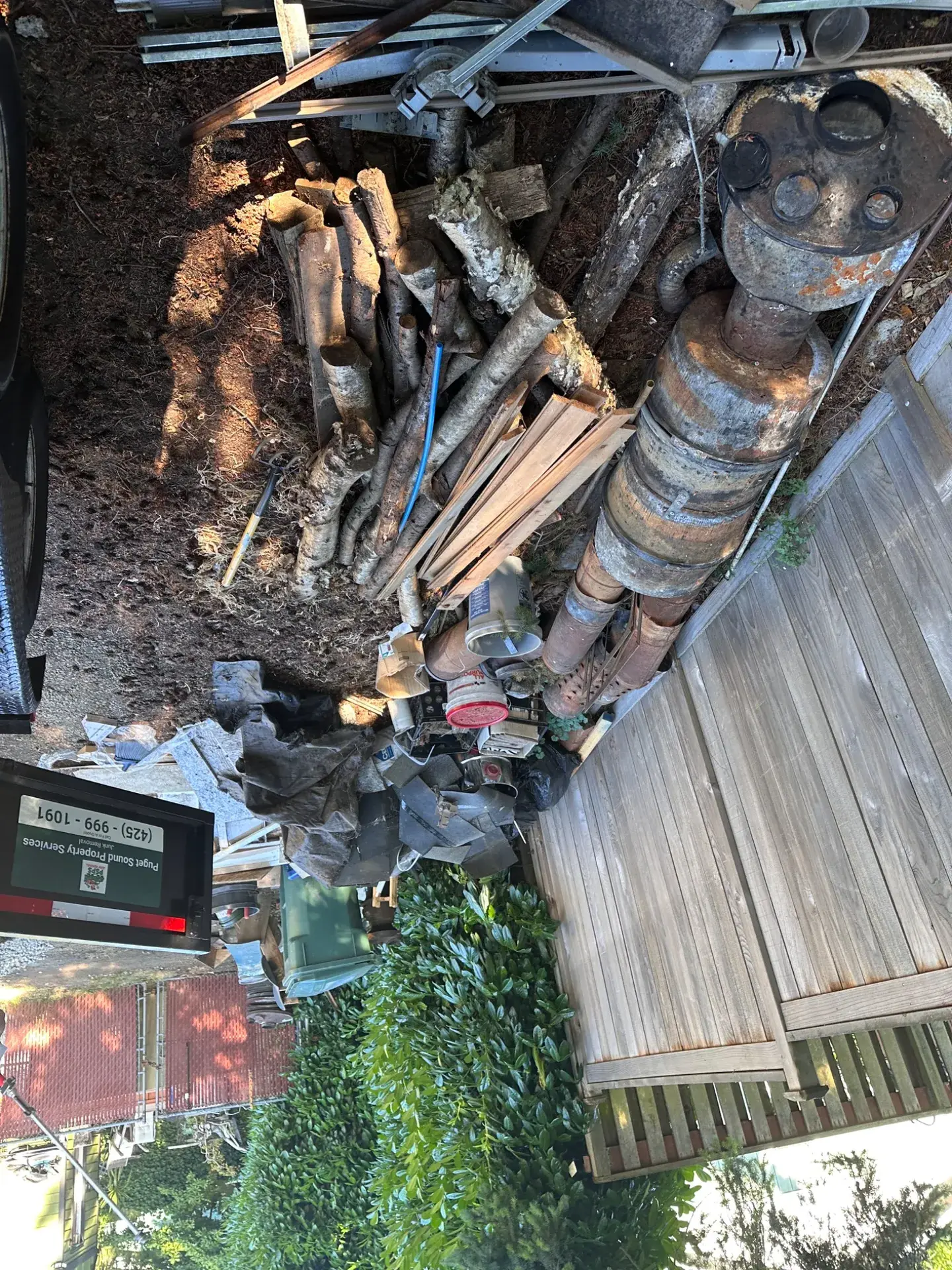 Truck loaded with an old oil tank, logs and scrap metal