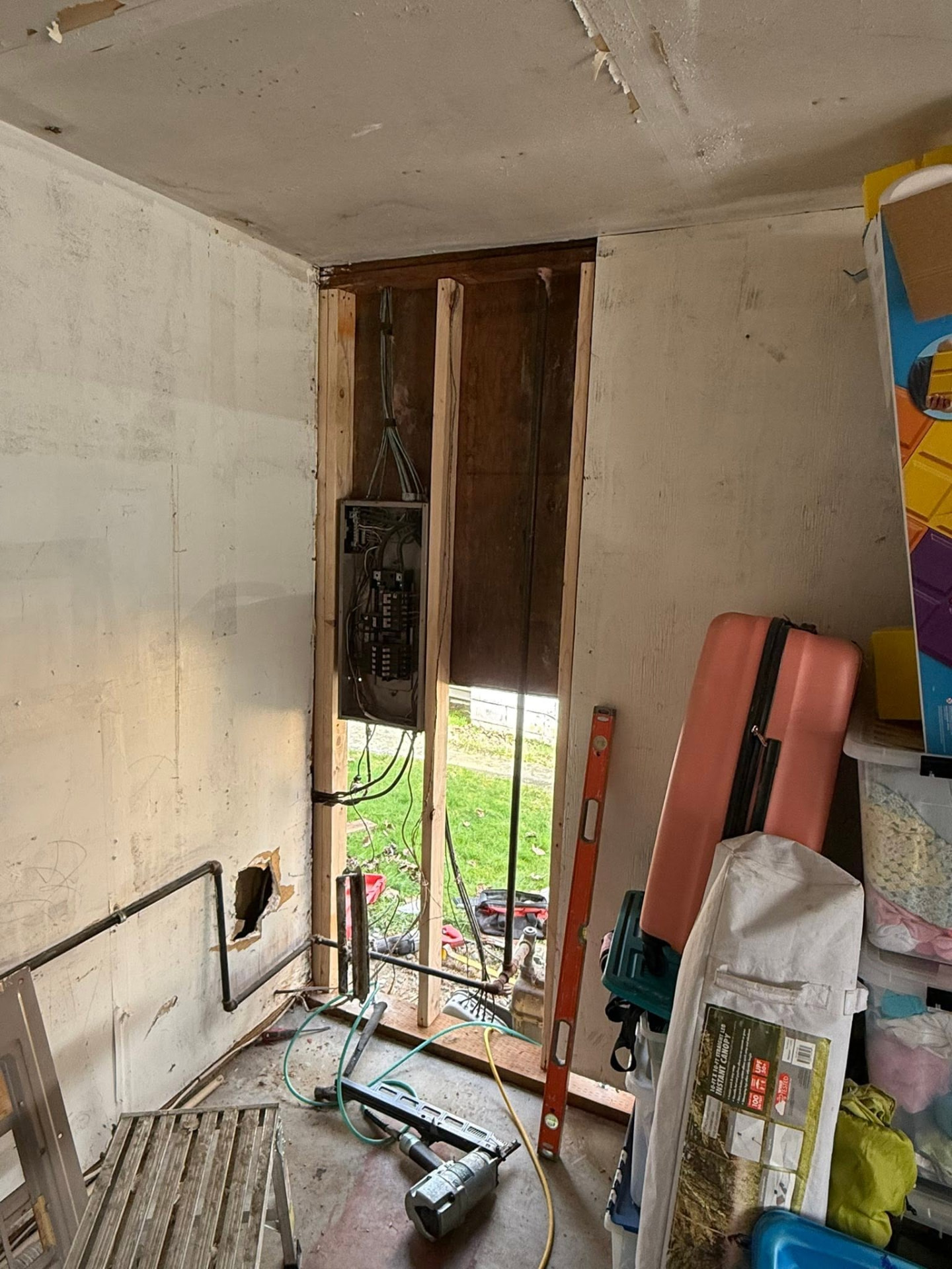 Interior wall opened to expose the electrical panel and new framing