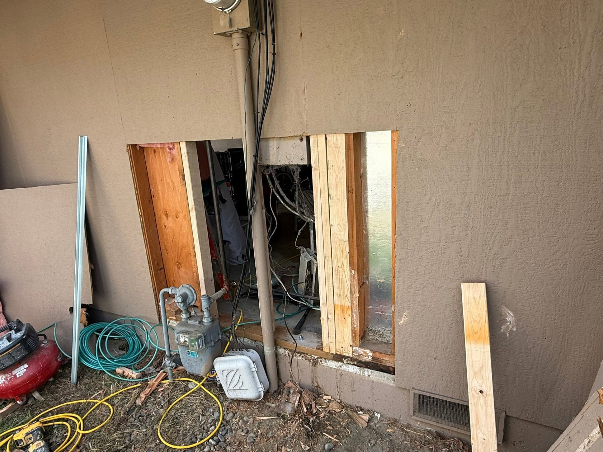 Exterior stucco wall opened around gas and electric meters with new framing