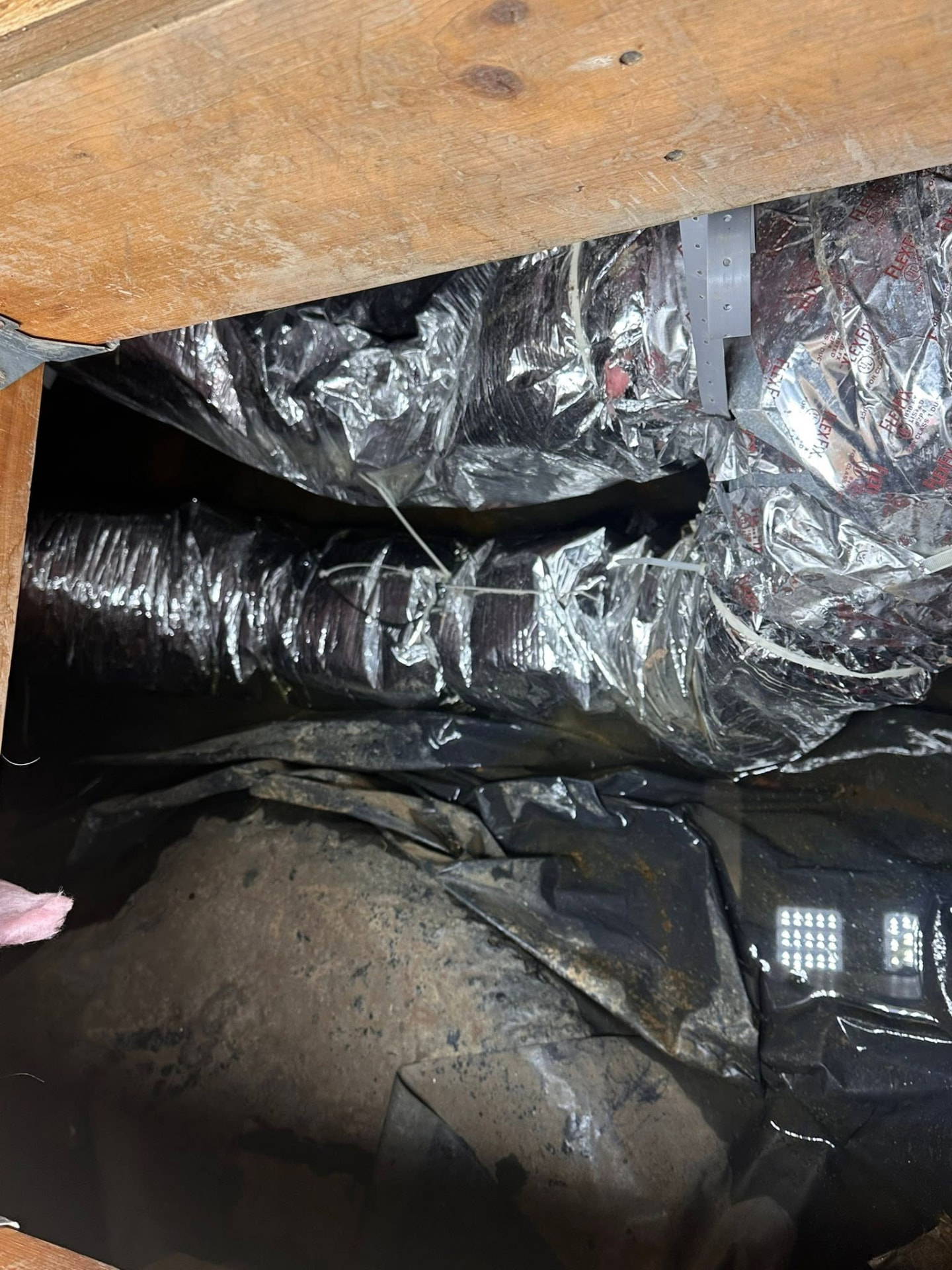 Standing water across a crawlspace vapor barrier under ductwork