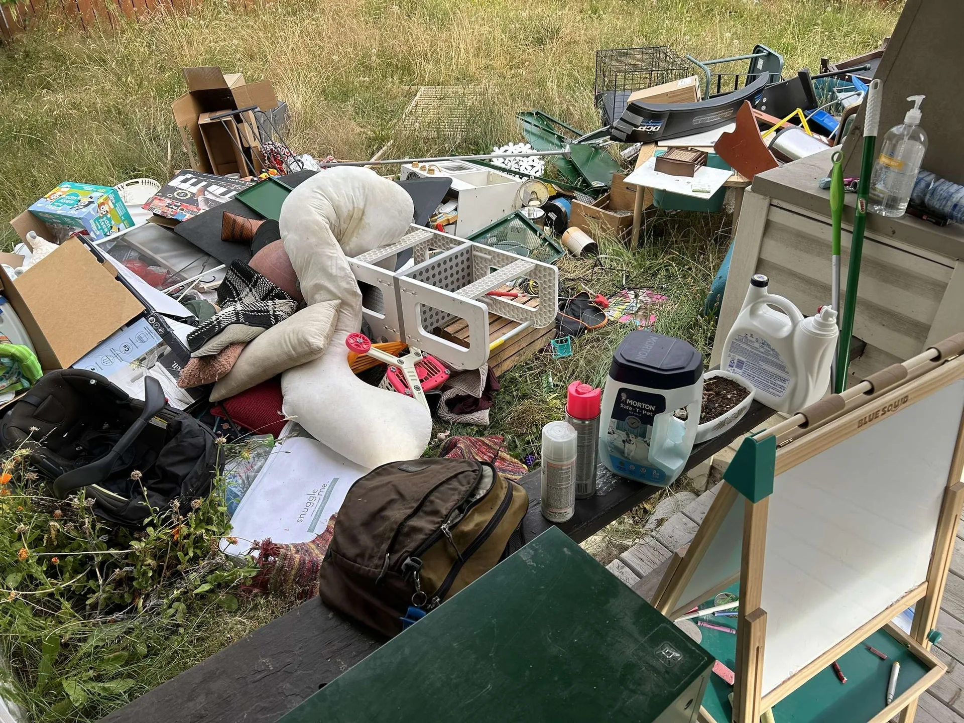 Large staged pile of household debris in a backyard