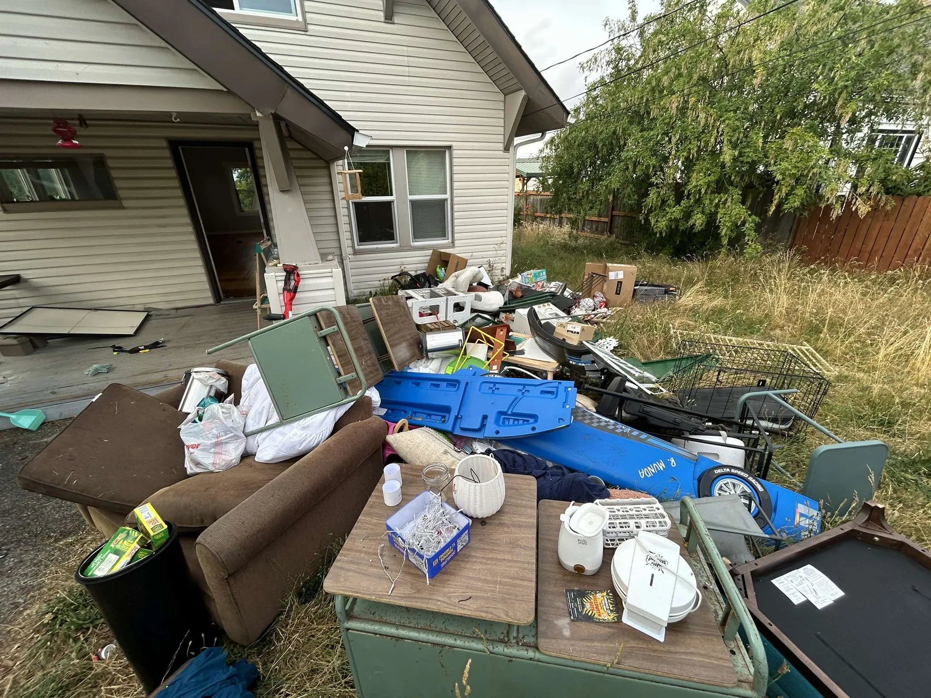 Entire contents of a vacant house piled in the yard beside the porch