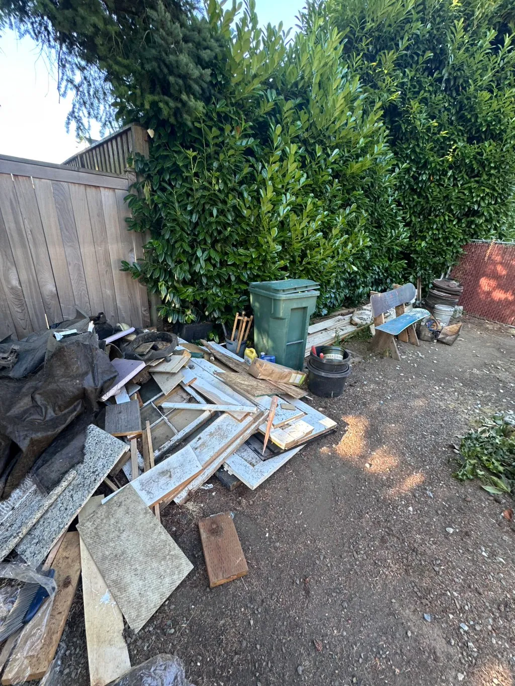 Side yard with sorted lumber and drywall debris